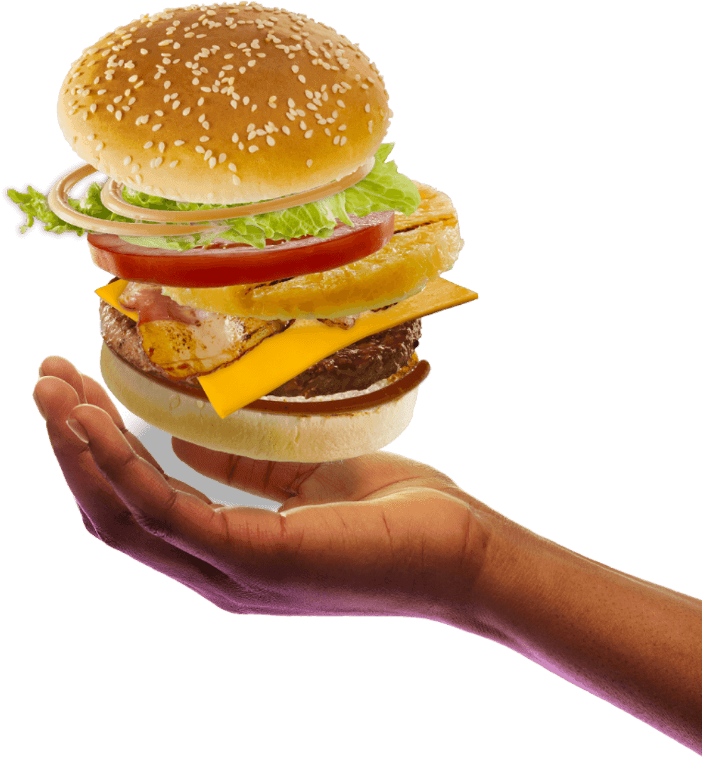 Hand holding a loaded cheeseburger with beef patty, grilled chicken, melted cheddar cheese, pineapple slice, lettuce, tomato, onions, sesame seed bun, and barbecue sauce